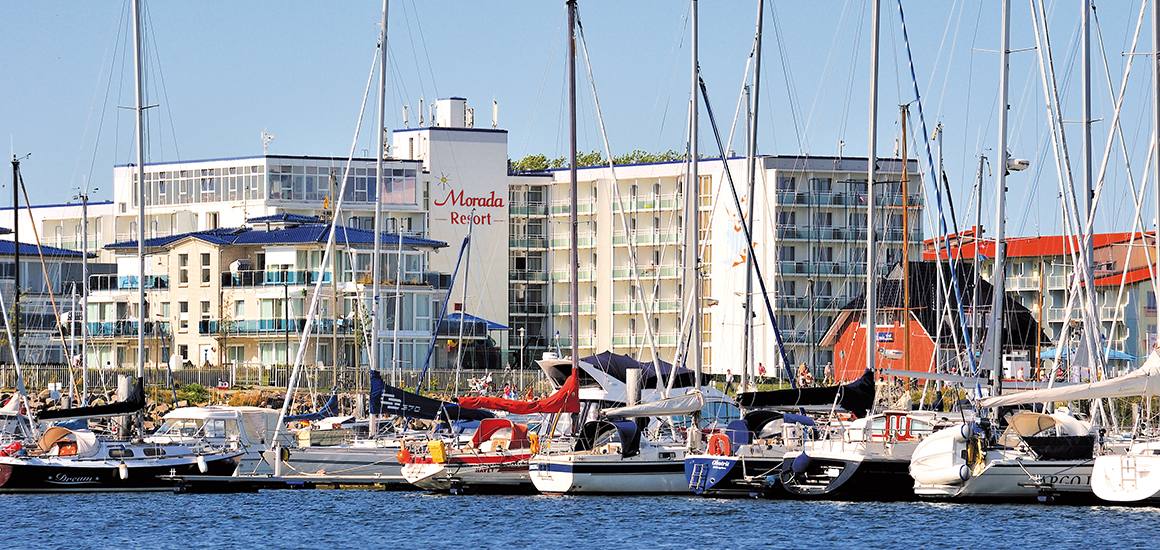 Ansicht eines Hotels in Kühlungsborn mit Segelbooten im Vordergrund.