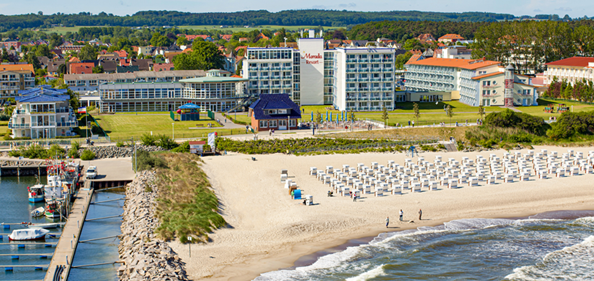 Luftaufnahme eines Hotels in Kühlungsborn an der Ostsee mit Strand und Strandkörben im Vordergrund.