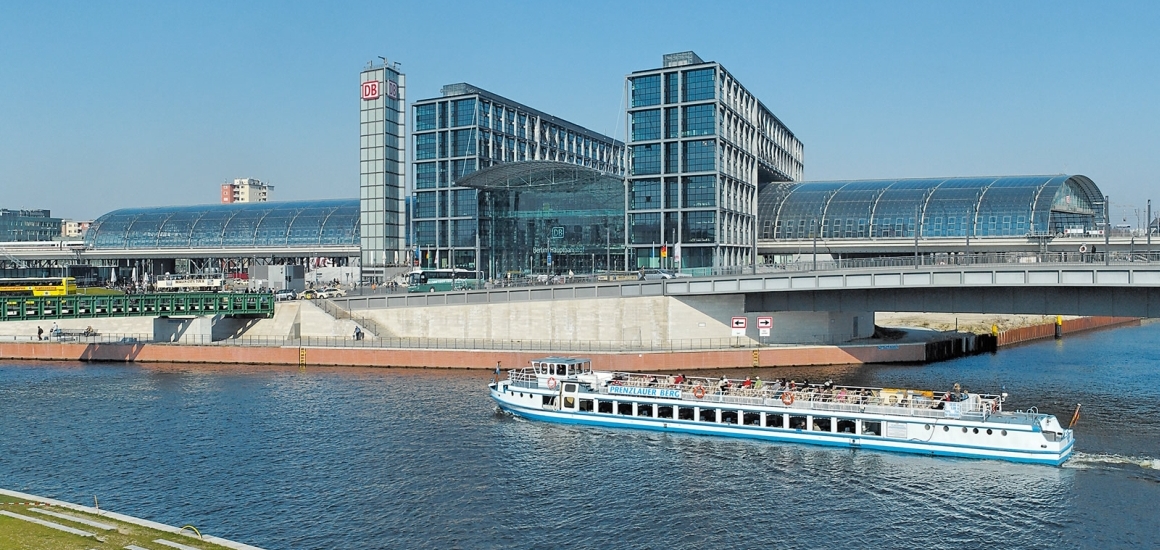 Berlin Hauptbahnhof mit vorbeifahrendem Boot auf der Spree