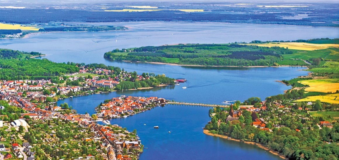 Luftaufnahme der Inselstadt Malchow in Mecklenburg-Vorpommern, umgeben von Wasser und grüner Landschaft.