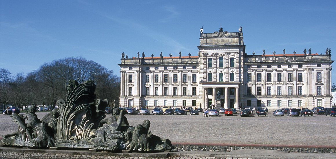 Schloss Ludwigslust in Mecklenburg-Vorpommern mit einem Brunnen im Vordergrund.