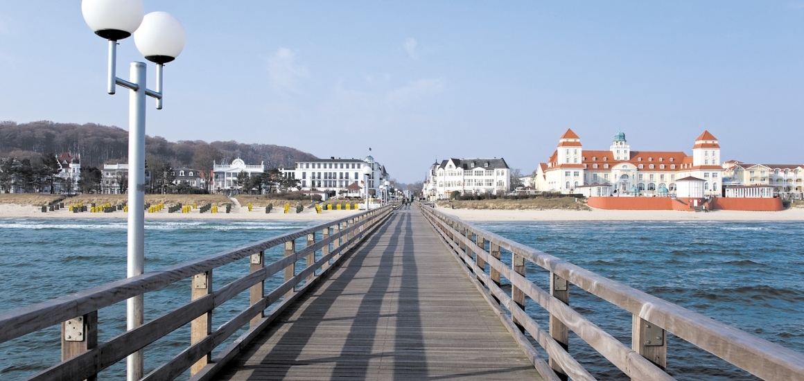 Seebrücke in Binz an der Ostsee mit Blick auf den Strand und die umliegenden Gebäude.