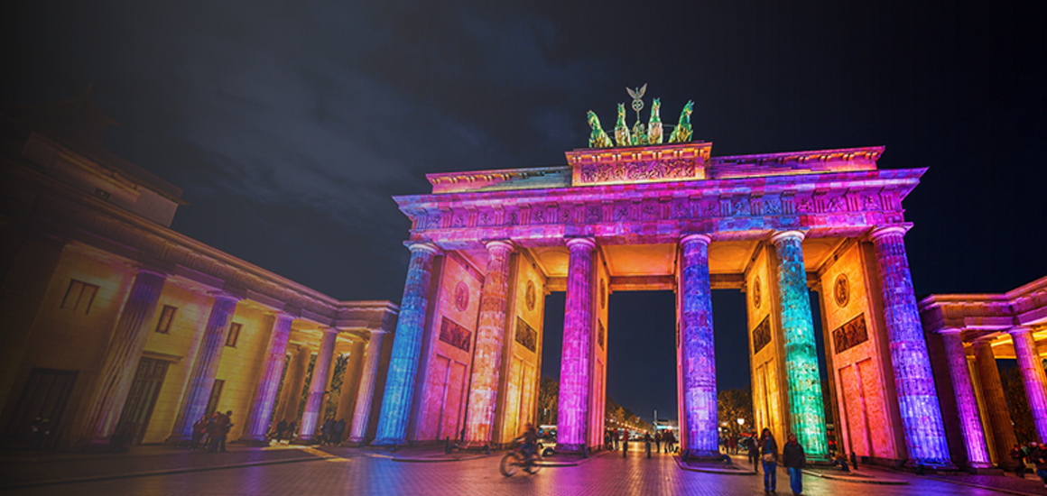 Das Brandenburger Tor erstrahlt bei Nacht in bunten Lichtinstallationen und sorgt für eine stimmungsvolle Festival-Atmosphäre in Berlin.&nbsp;KI-unterstützte Bildgenerierung
