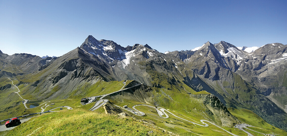 Panoramablick auf die Großglockner Hochalpenstraße mit kurvenreicher Straße und umliegenden Bergen.