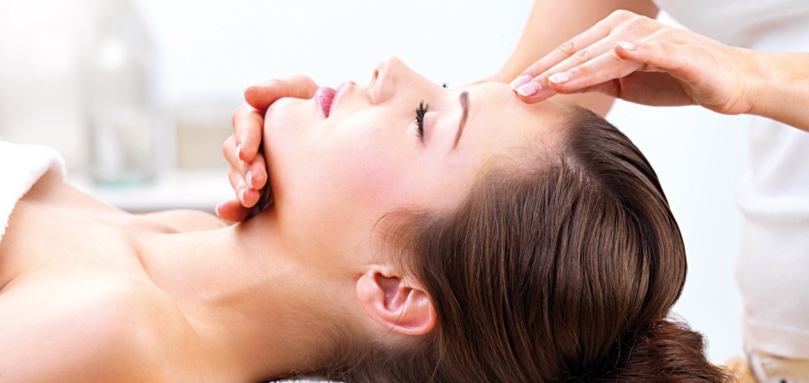 Eine Person erhält eine Gesichtsmassage in einer Wellness-Umgebung.