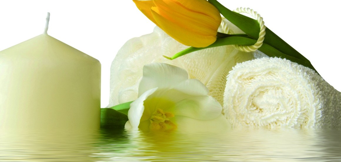 Stilleben mit einer weißen Kerze, einer gelben Tulpe, einem weißen Handtuch und einer weißen Blume, die auf einer reflektierenden Oberfläche arrangiert sind.
