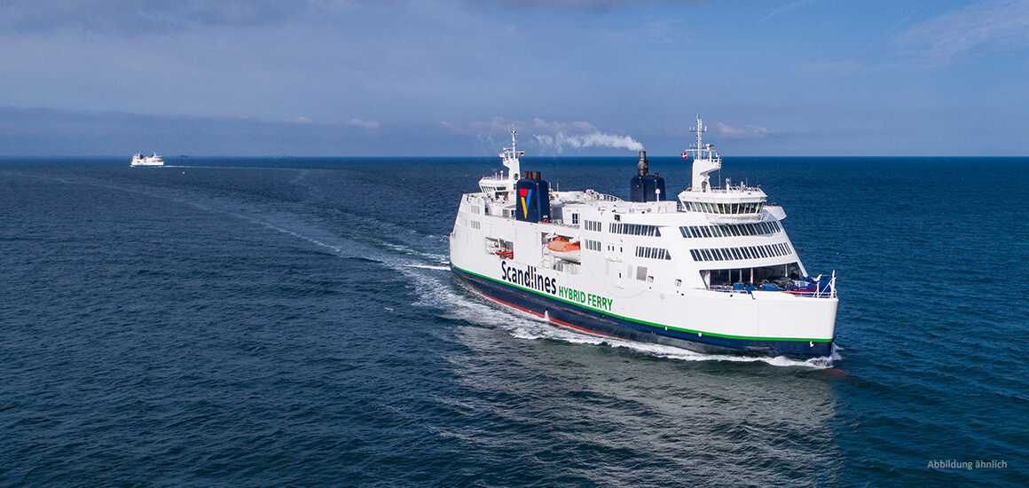 Ein großes Fährschiff der Reederei Scandlines fährt auf dem Meer. Im Hintergrund ist ein weiteres Schiff zu sehen. Der Himmel ist leicht bewölkt.